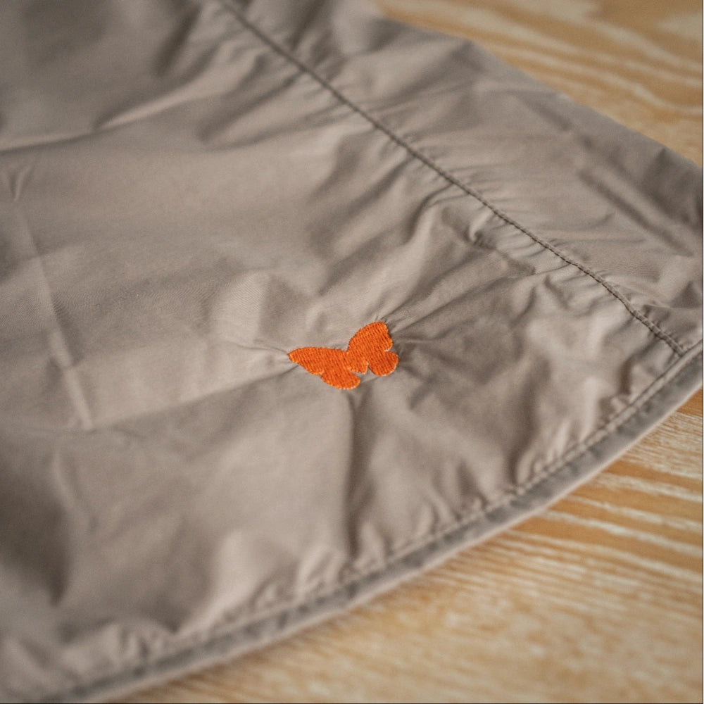 Close-up of Monarch Flyway orange butterfly logo on vest